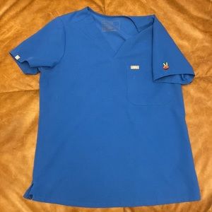 Royal blue fig Catarina scrub top with equality peace sign on left shoulder